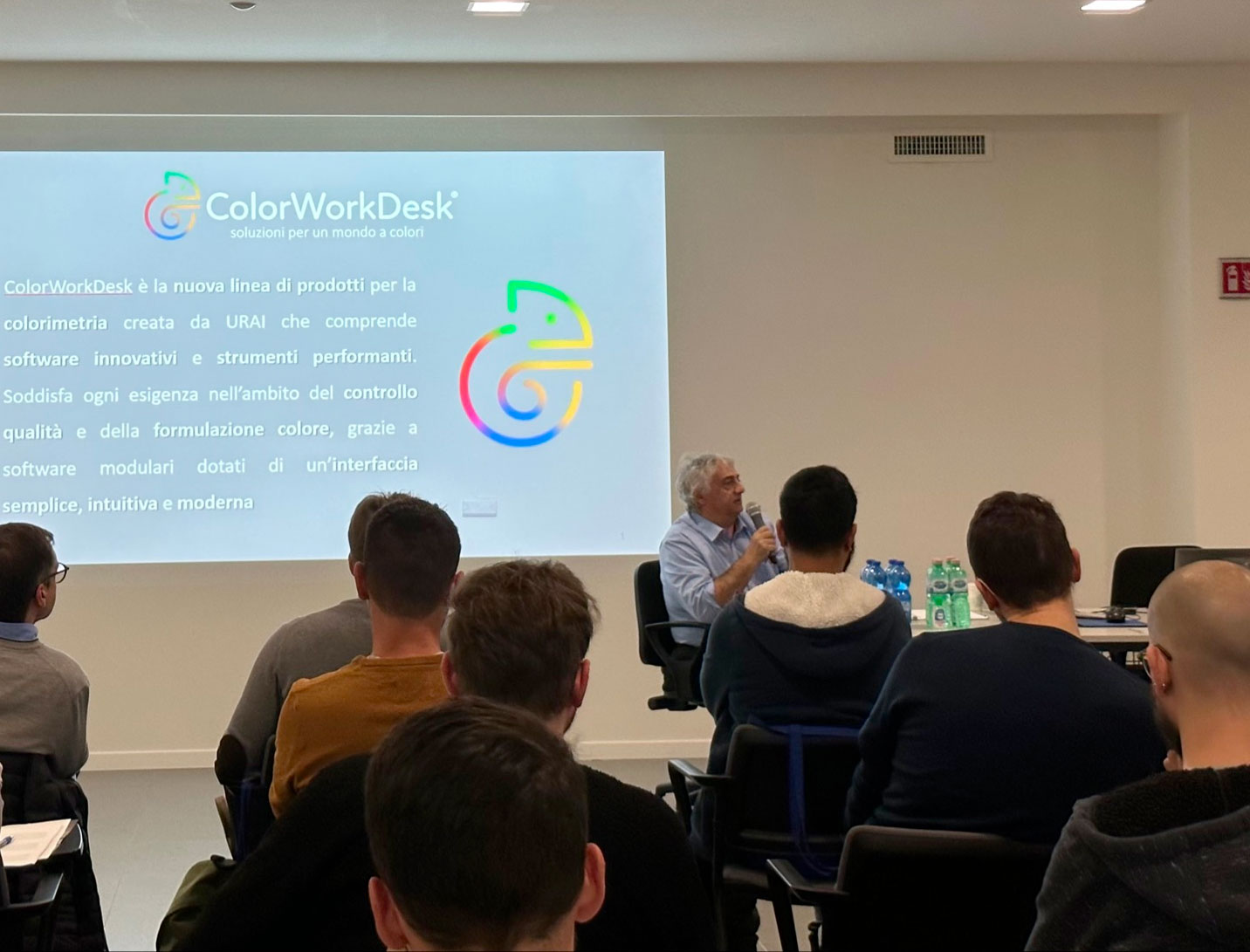 Una platea di persone che ascoltano il docente che parla di Colorimetria